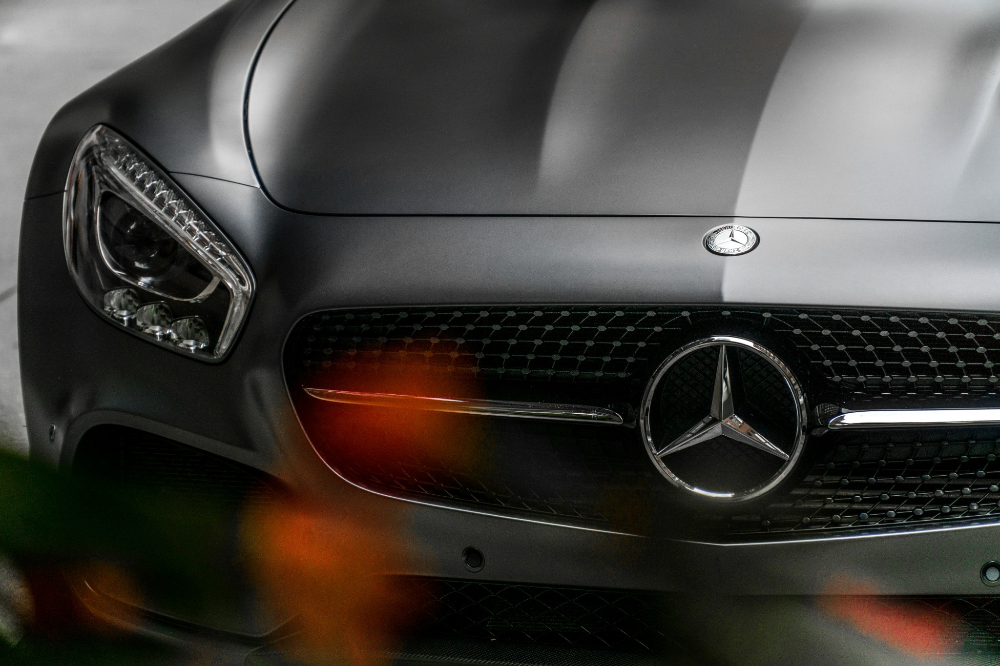 Front grille and headlight of a black Mercedes-Benz sports car