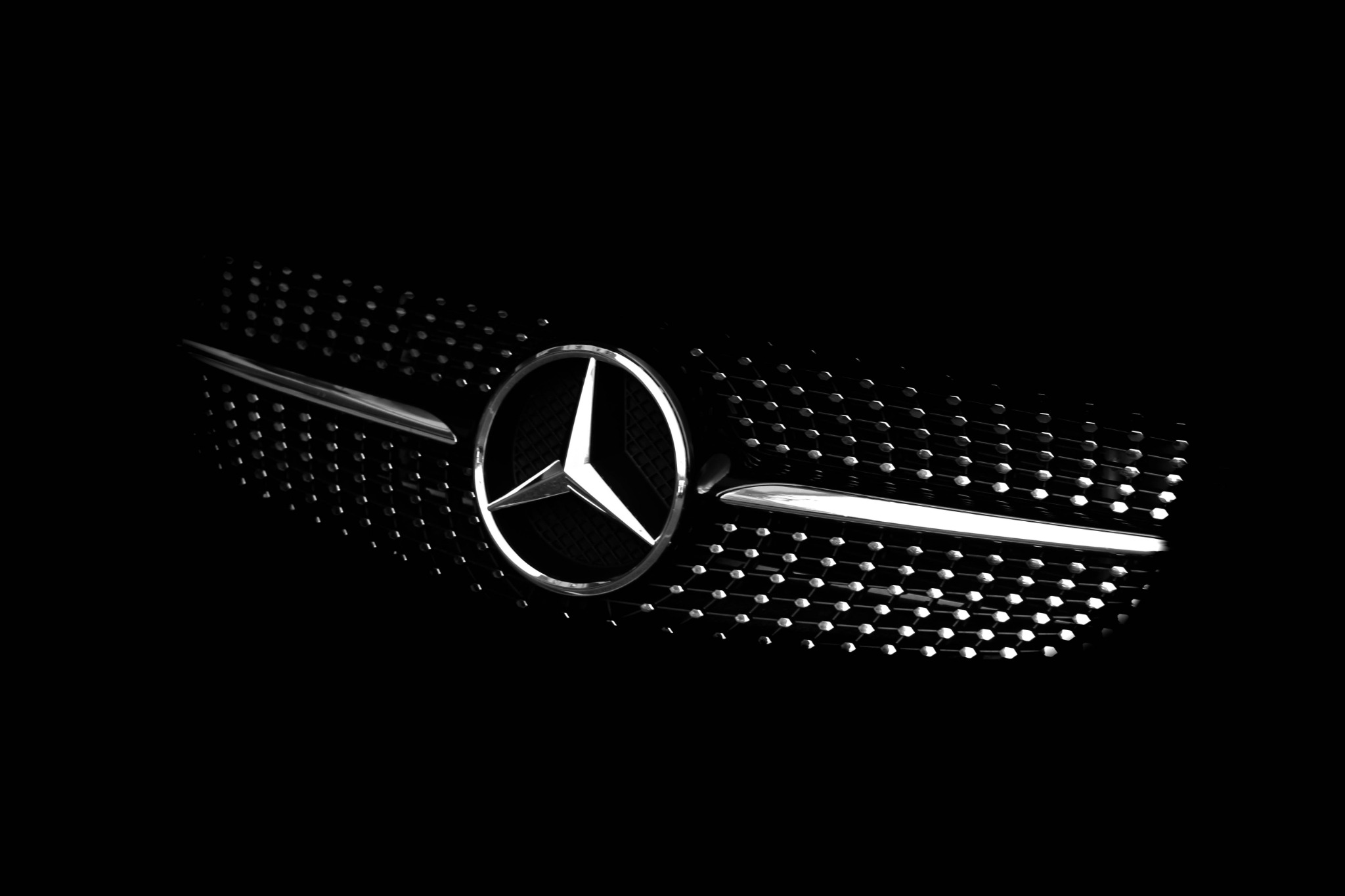 Mercedes-Benz logo on black grille with chrome detailing